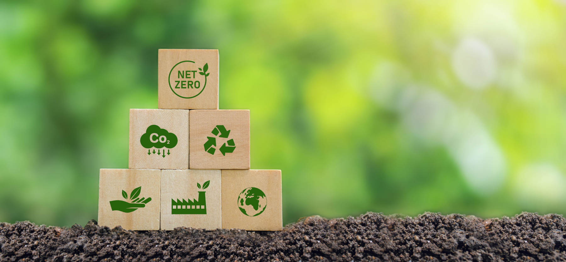 Stacked carbon reduction icons in soil with a green background